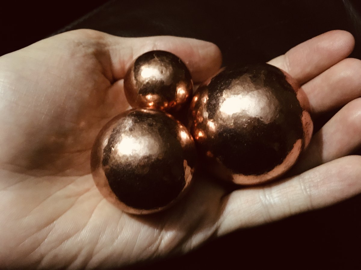 Me holding three shiny copper spheres